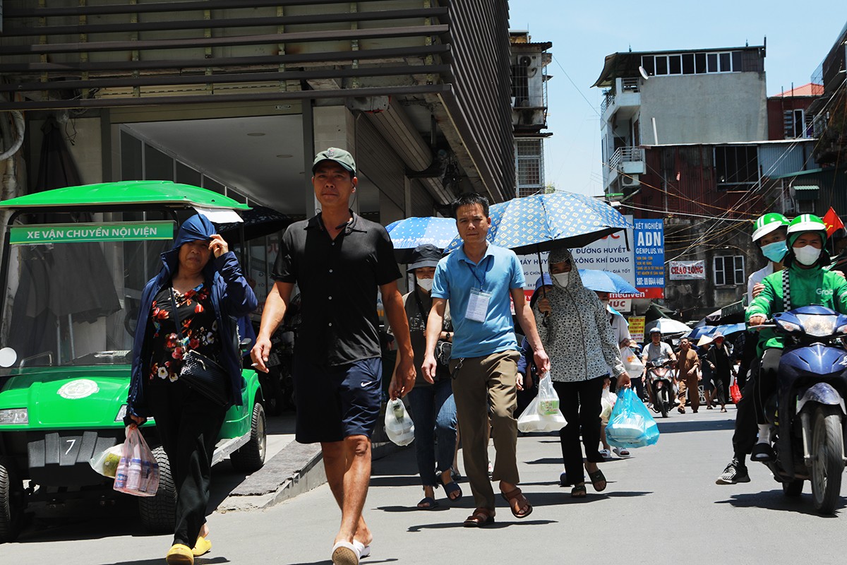 Người nhà bệnh nhân mua đồ ăn từ quán ăn ở ngõ 4 phố Phương Mai mang vào bệnh viện Bạch Mai.