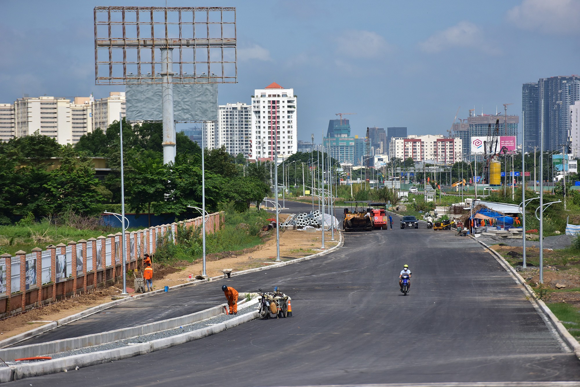 Trên dọc công trình, nhiều nhóm công nhân đang thi công vỉa hè, hệ thống chiếu sáng, sơn kẻ vạch đường… Sau 4 năm trễ hẹn, phần lớn công trình đang chuẩn bị về đích.