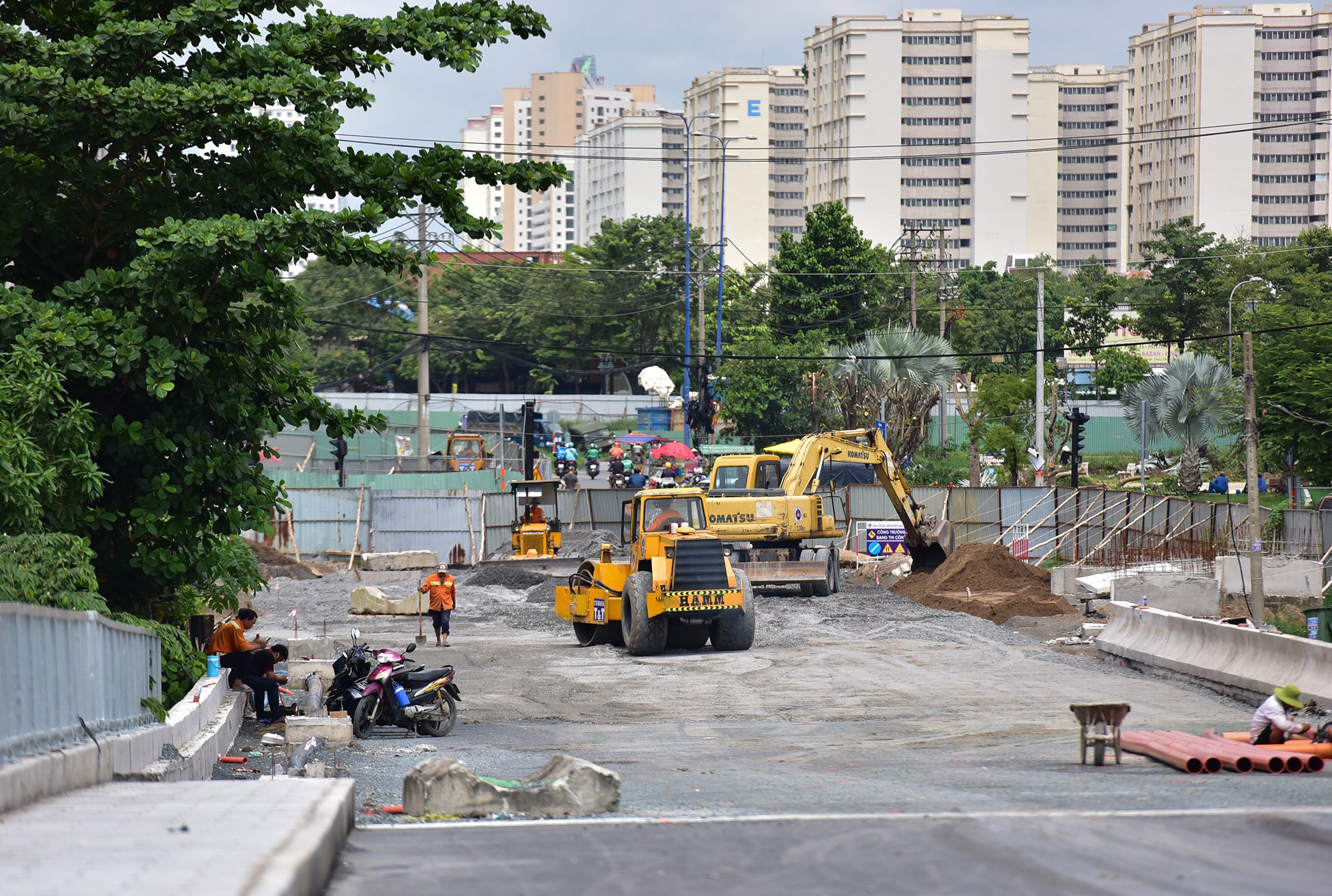 Máy móc, công nhân khẩn trương san nền đá dăm mặt đường chân cầu Bà Dạt, đoạn giao với đường Nguyễn Thị Định.