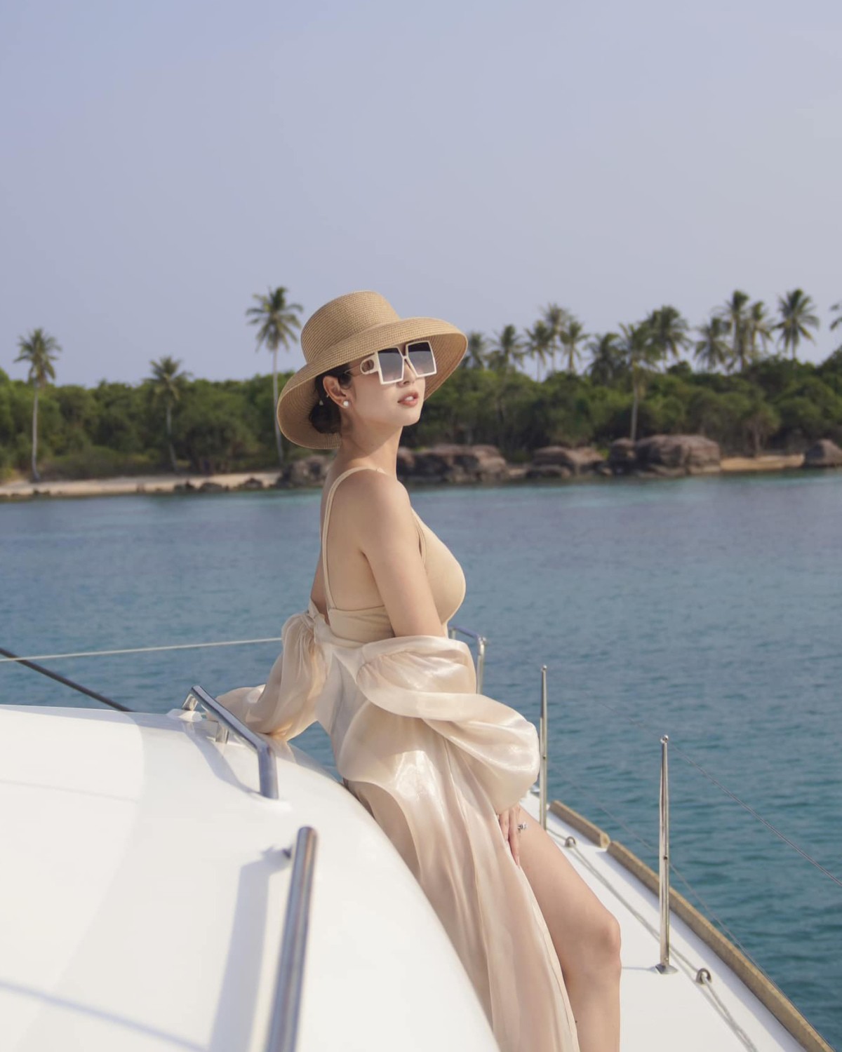 Jennifer Phạm diện monokini trên du thuyền. Cô phối với áo choàng và mũ cói có cùng tông màu để tạo nên một tổng thể đồng nhất.