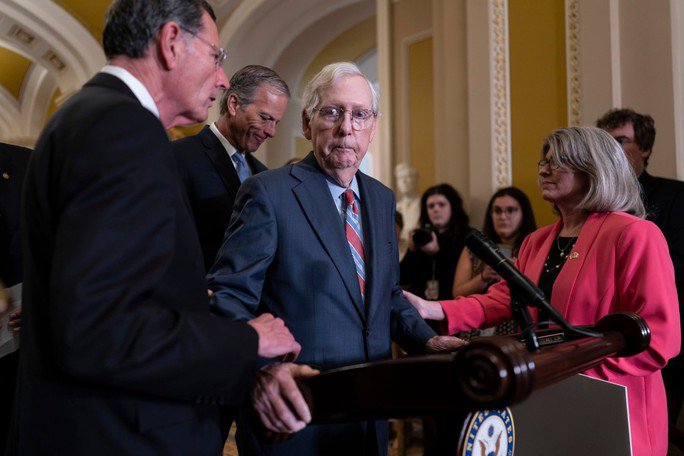 Ông Mitch McConnell được các đồng nghiệp giúp đỡ sau khi "đứng hình" trong một cuộc họp báo. Ảnh: AP
