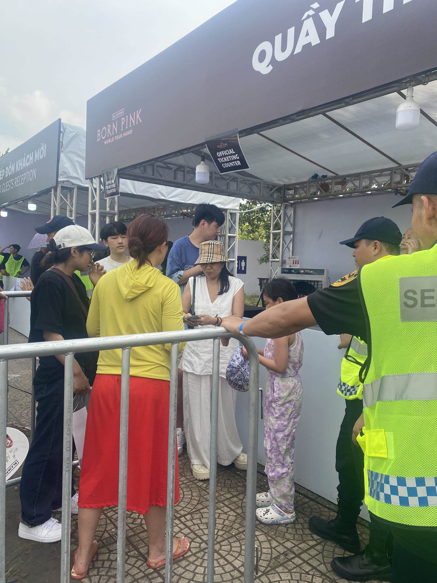 Người phụ nữ áo trắng dắt theo 2 con nhỏ, phải đi rút tiền mặt mới có thể mua được 3 vé.