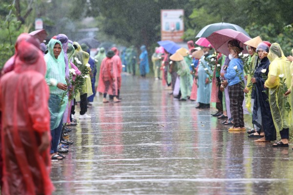 Từ sáng sớm, bất chấp cơn mưa lớn kéo dài, hàng trăm người dân đã xếp hàng đội mưa chờ đón liệt sĩ Lê Ánh Sáng.