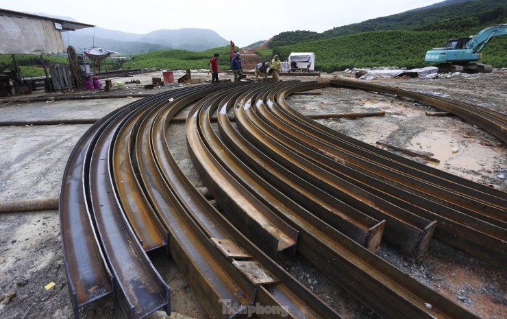 Bên ngoài, các công nhân đang hàn cấu kiện thép vòm, đỡ trong quá trình thi công hầm xuyên núi.
