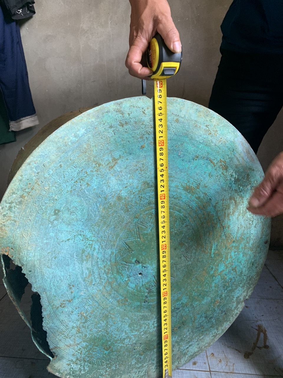 Chiếc trống đồng màu xanh, bị sứt một góc rộng khoảng 20cm. Ảnh: Cổng thông tin điện tử huyện Mèo Vạc