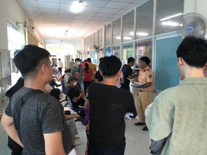 Người dân xếp hàng làm thủ tục sang tên, đổi chủ, thu hồi biển số... ở trụ sở Đội CSGT - Trật tự Công an quận 7. Ảnh: Đại Nguyên