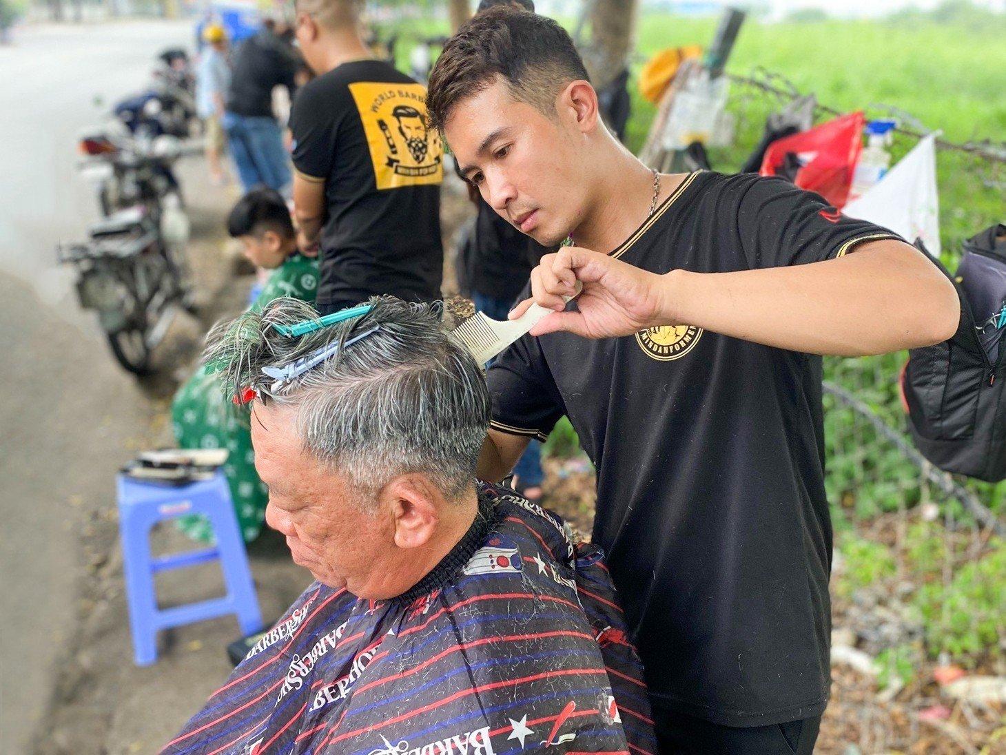 Học viên Minh Đan cắt tóc cho người dân tại Khu công nghiệp Tân Bình