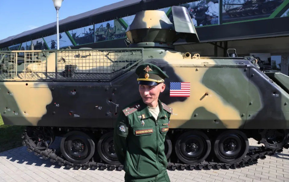 Một quân nhân Nga chụp ảnh gần chiếc xe bọc thép chở quân M113 của Mỹ. Ảnh: Getty