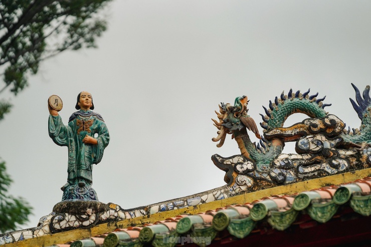 Đặc sắc nhất vẫn là phần mái với họa tiết bát tiên, rồng chầu. Góc trái của mái lăng là vị tiên cầm chữ Nguyệt.