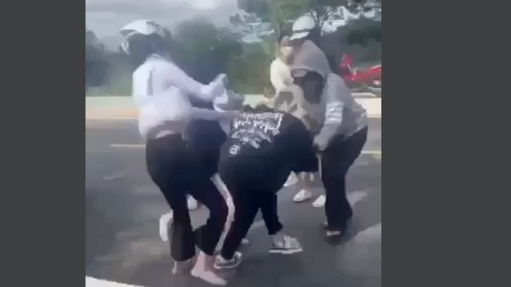 Nhóm năm phụ nữ đánh cô gái bằng nón bảo hiểm. Ảnh cắt từ clip