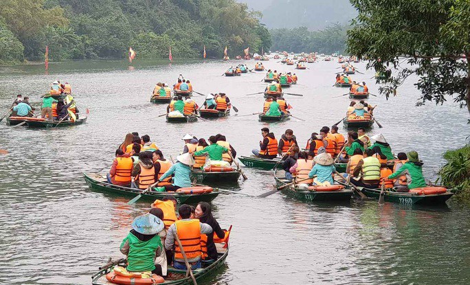 Khách du lịch đi thuyền tham quan Tràng An, một danh thắng nổi tiếng ở huyện Hoa Lư, tỉnh Ninh Bình. Ảnh: T.Tuấn