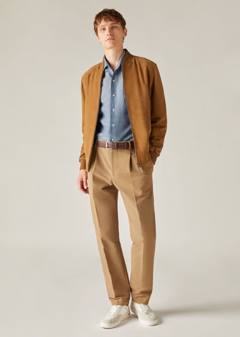 Thêm sức hấp dẫn giản dị cho chiếc áo sơ mi và quần xếp ly bằng cách bổ sung thêm áo khoác bomber da lộn. 