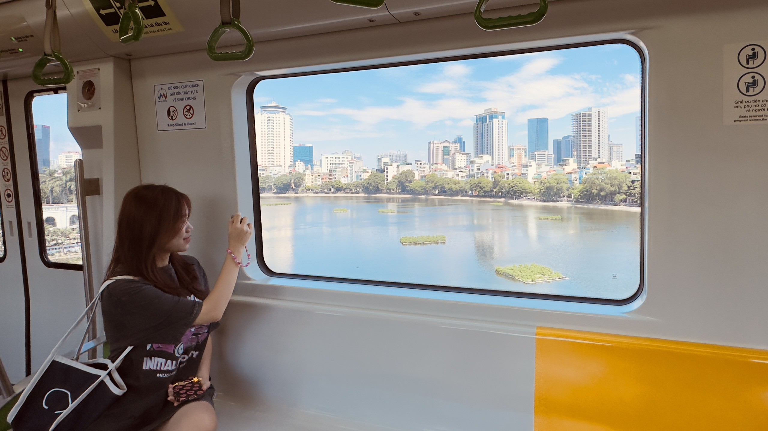 Nhiều hành khách thích thú ghi lại cảnh đẹp qua ô cửa kính tàu điện.
