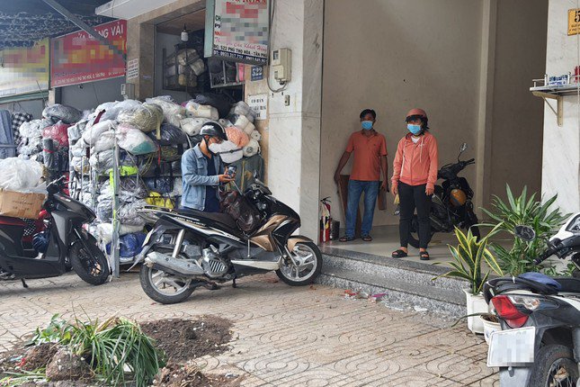 Mảnh vỡ thủy tinh và đất cát vương vãi khắp nơi trước cửa hàng vải của gia đình bà S. Ảnh: Hoàng Thuận.