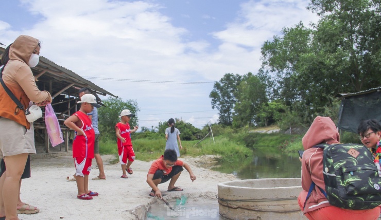 Du khách, đặc biệt các em nhỏ tỏ ra rất thích thú khi trải nghiệm tận tay luộc trứng dưới dòng nước nóng tự nhiên. (Ảnh: Trương Định).