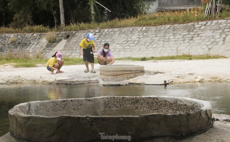 Các em nhỏ rất thích thú khi cùng với gia đình trải nghiệm luộc trứng tại suối nước nóng Hội Vân. (Ảnh: Trương Định)