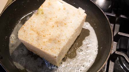 Cắt ổ bánh mì làm đôi. Đun chảy bơ trên chảo chống dính, cho bánh mì vào rán vàng 4 mặt. Bạn cũng có thể nướng trong nồi chiên không dầu bằng cách phết bơ khắp các mặt, nướng 170 độ C trong 5 phút.