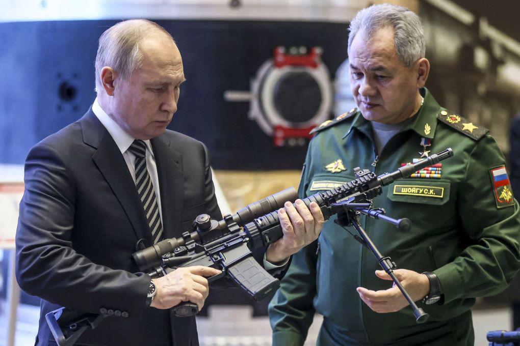 Ông Putin kiểm tra một khẩu súng (ảnh: RT)