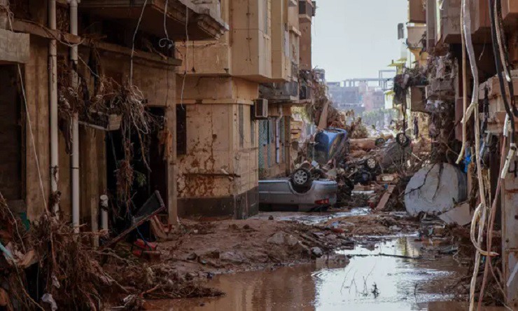 Một xe hơi bị lật úp giữa khung cảnh đổ nát ở thành phố Derna, Libya.