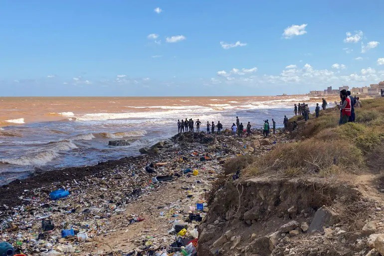 Các nhóm cứu hộ tìm kiếm thi thể trôi dạt trên bờ biển ở thành phố Derna, Libya.