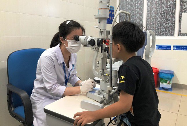 Bác sĩ khám cho trẻ em bị đau mắt đỏ.