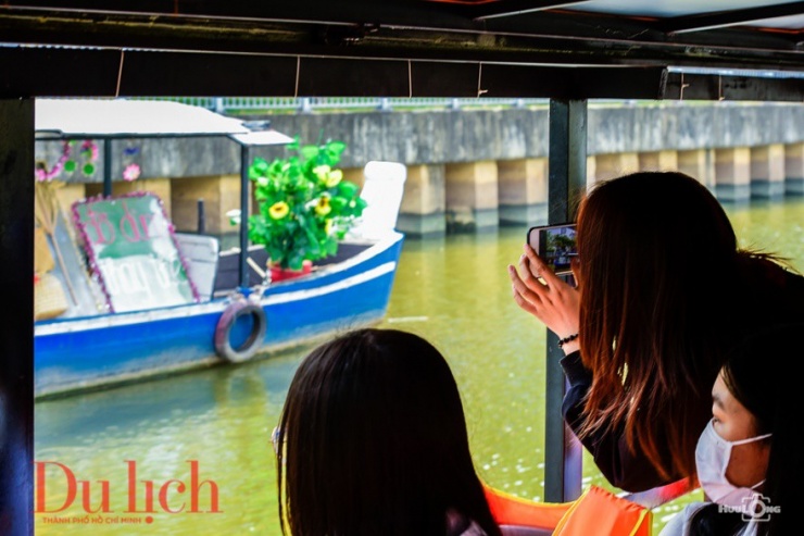 Du khách thích thú chụp ảnh và ghi lại những thước phim cảnh quan 2 bên bờ và những chiếc thuyền trang trí sinh động, vui nhộn mang thông điệp xanh – bảo vệ mội trường.