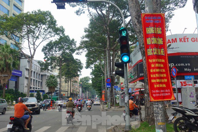 Người dân khu vực cho biết, việc tháo gỡ các tấm cỏ nhựa, cỏ nhân tạo đã được cơ quan chức năng địa phương thực hiện từ ngày hôm qua (22/9). Trong ảnh: Một số trụ đèn chiếu sáng trên đường Trần Hưng Đạo (phường 2, quận 5) đã được tháo tấm cỏ nhựa và treo băng rôn yêu cầu không xả rác.