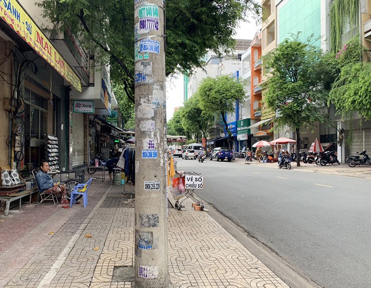 Những trụ điện này được ốp cỏ nhựa cao khoảng 2,5m ngăn không cho dán quảng cáo, bôi bẩn. Sau khi tháo lớp cỏ nhựa, trên các trụ thép vẫn còn dấu cạo xóa, giấy rao vặt cũ.