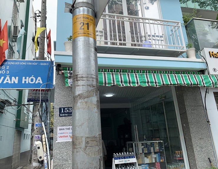 Cột đèn chiếu sáng trên đường Trần Bình Trọng trước và sau khi tháo lớp cỏ nhựa.