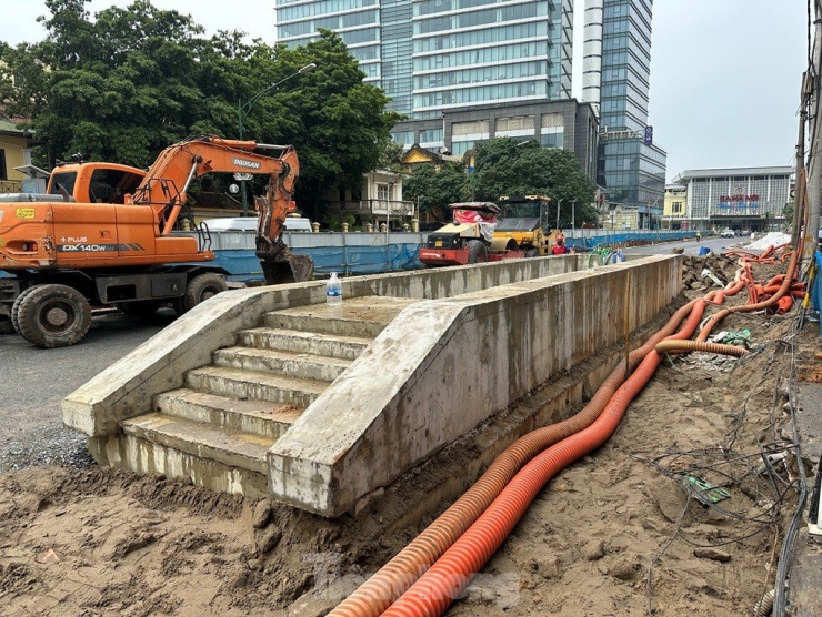 Đến nay, việc xây lắp ga ngầm đã xong cơ bản, công trình đã được hoàn trả mặt bằng bên trên. Hiện dự án chỉ có phần cửa đi xuống hầm là nổi lên khỏi mặt đất, các đơn vị thi công đang tiếp tục hoàn thiện các công việc còn lại.