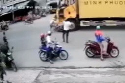 Clip: Đi vào ”vùng cấm kỵ”, 2 người đi xe máy bị xe tải đè xuống gầm, may mắn thoát đại nạn