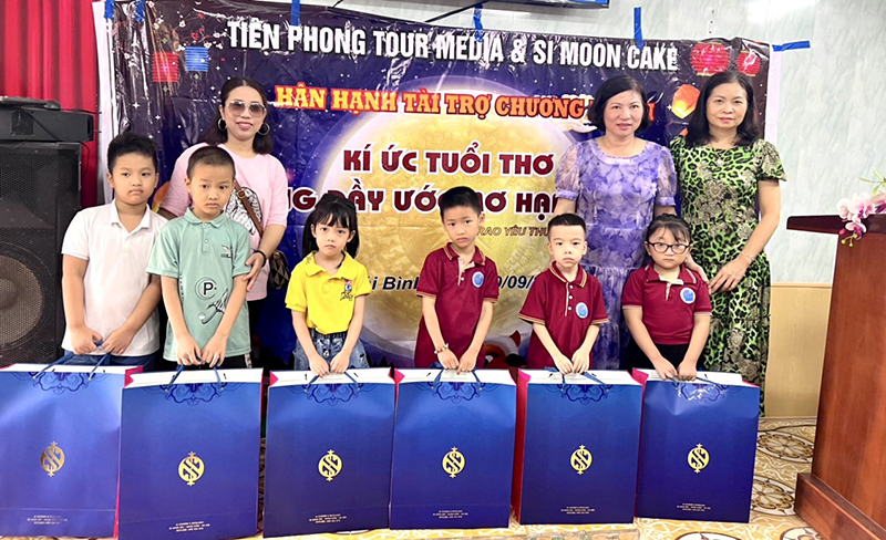 Bà Trần thị Thùy bên trái phát quà trung thu cho các con trường tiểu học Quang Trung – Thành phố Thái Bình.