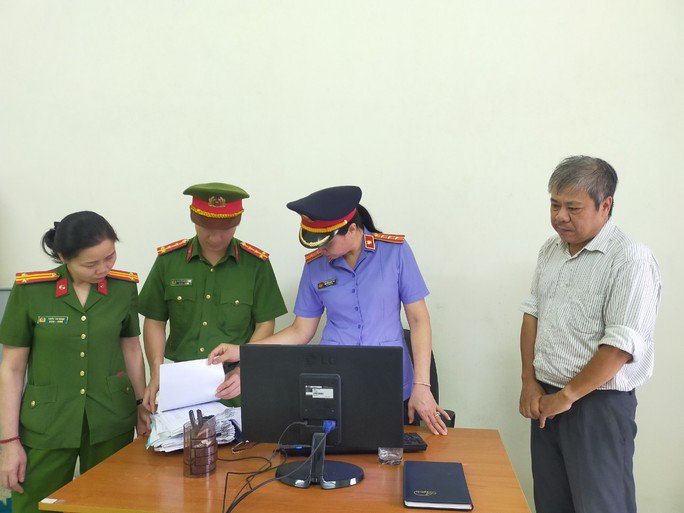 Cơ quan Cảnh sát điều tra Công an tỉnh Thanh Hóa khám xét nơi làm việc của Nguyễn Giang Quân (bị can Quân ngoài cùng bên phải). Ảnh: Công an Thanh Hóa