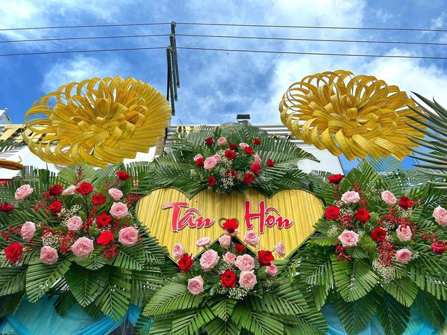 Hoa tươi được cắm xen kẽ khiến cổng cưới càng thêm rực rỡ.