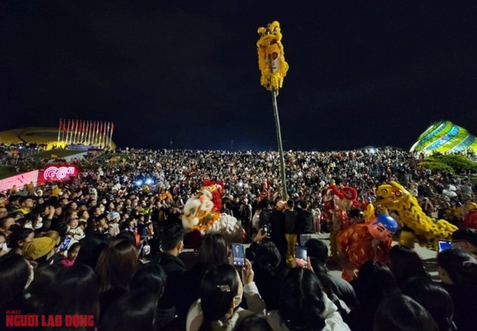 Khán giả phấn khích cổ vũ khi chứng kiến các động tác biểu diễn của lân trên cao.