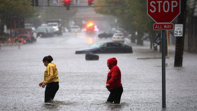 Người dân đi bộ qua vùng nước lũ ở vùng ngoại ô Mamaroneck, TP New York hôm 29-9. Ảnh: Reuters