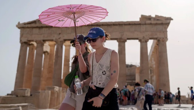 Du khách che ô để tránh nắng hè tại Athens, Hy Lạp. Ảnh: AP