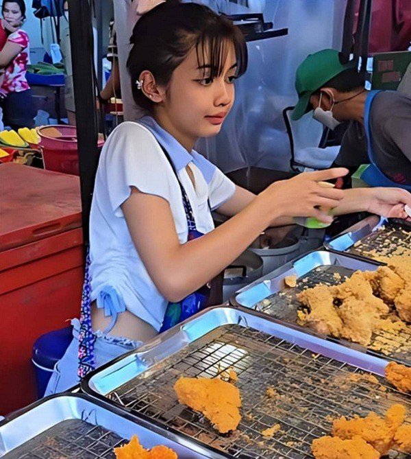 Cô gái bán gà rán ở một khu chợ tại Thái Lan. Ảnh: SCMP.