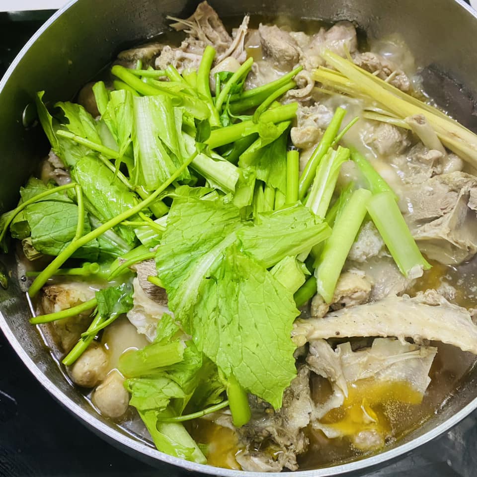 Khi khoai môn mềm thì cho rau muống và cải xanh vào nồi, nấu đến khi rau vừa chín tới thì hoàn tất.