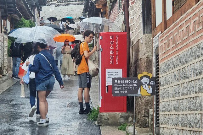 Biển báo yêu cầu du khách nói nhỏ ở khu làng cổ. Ảnh: Rhee Soo-young/CNN.
