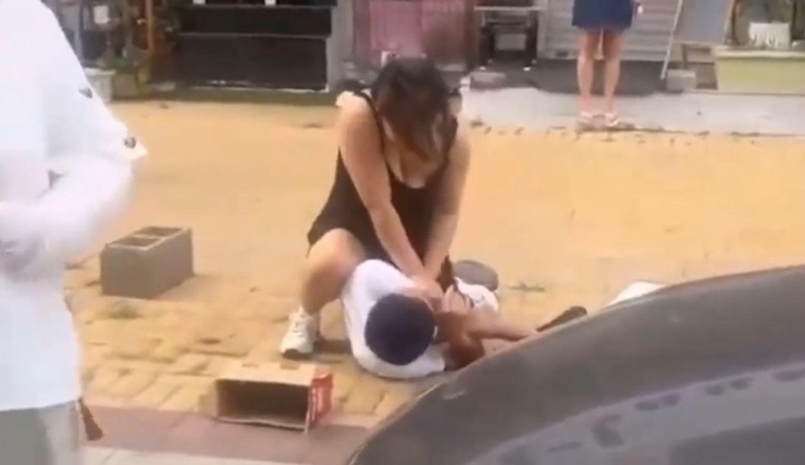 Tên biến thái bị nữ nhân viên khống chế trên phố.