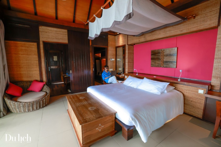 Không gian phòng ấm cúng với tông màu đỏ và cam gỗ sang trọng.