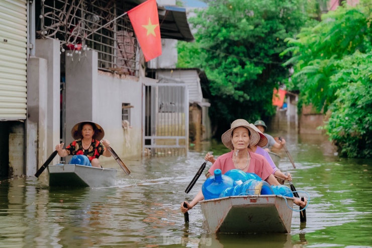 Người dân vùng lũ Chương Mỹ chèo thuyền nhận đồ hỗ trợ - 7