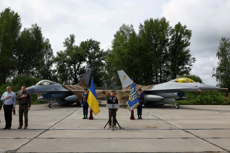 Ông Zelensky phát biểu bên cạnh 2 chiếc F-16 ở một địa điểm bí mật (ảnh: Al Jazeera)