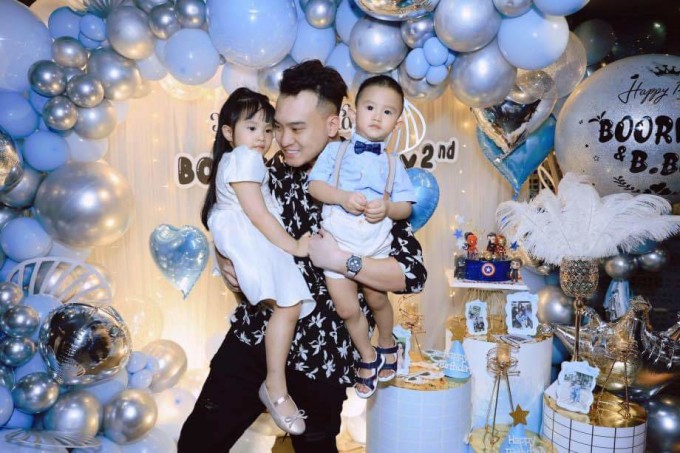 Nghiêm Đức âu yếm hai con trong tiệc sinh nhật chung của các bé năm 2021.