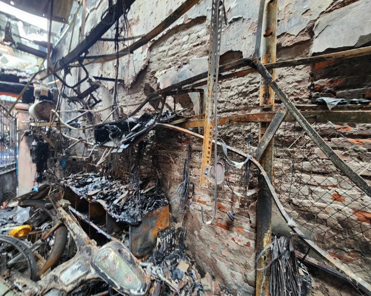 Bên trong khoảng sân chứa nhiều vật tư, linh kiện, phụ tùng của xe điện. Các giá treo chật kín đồ dùng.