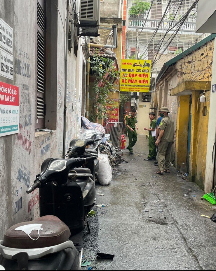 Nhiều xe máy xếp dọc con ngõ rộng khoảng 2 m, trước khu nhà bị cháy.