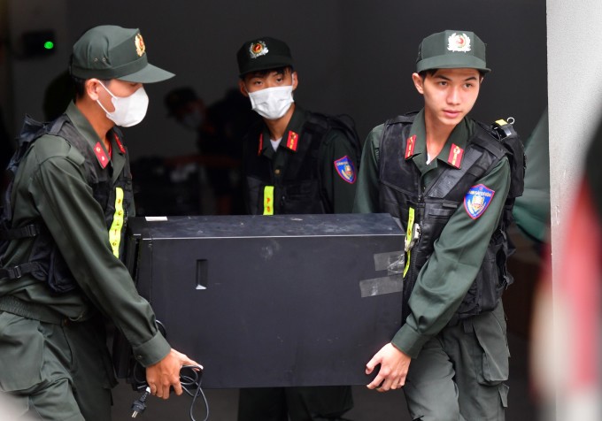 Gần 15h, cảnh sát đưa hàng chục thùng carton đựng tài liệu lên xe công vụ. Ảnh: Thanh Tùng