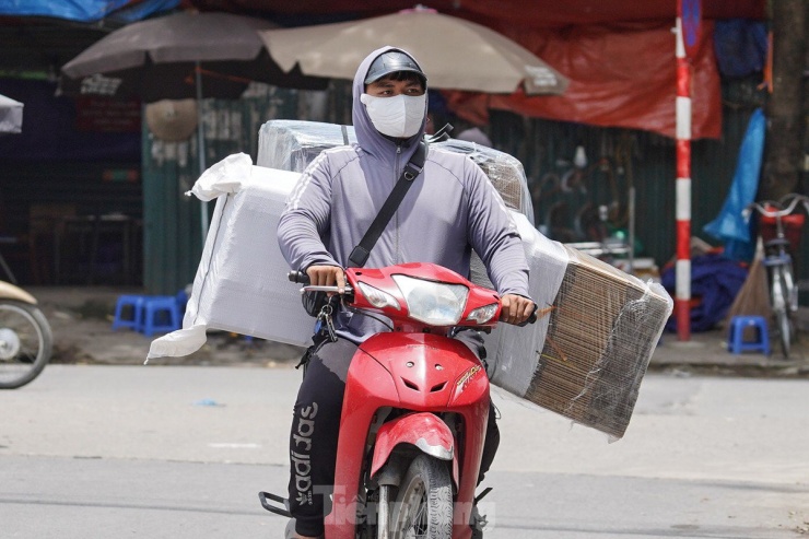 Các tài xế giao hàng cũng phải trang bị áo chống nắng, trùm kín từ trên đầu để có thể làm việc dưới cái nắng gay gắt ở Hà Nội.