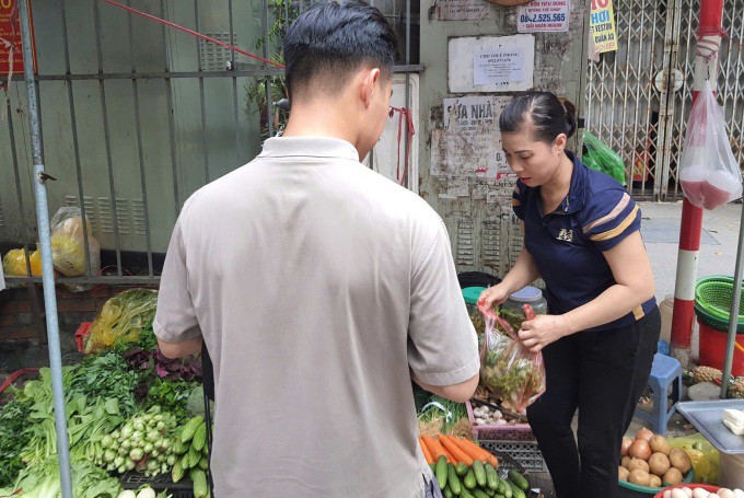 Một nam giới mua đồ ăn cho gia đình tại chợ ở Cầu Giấy, Hà Nội, hôm 22/8. Ảnh: Phạm Nga